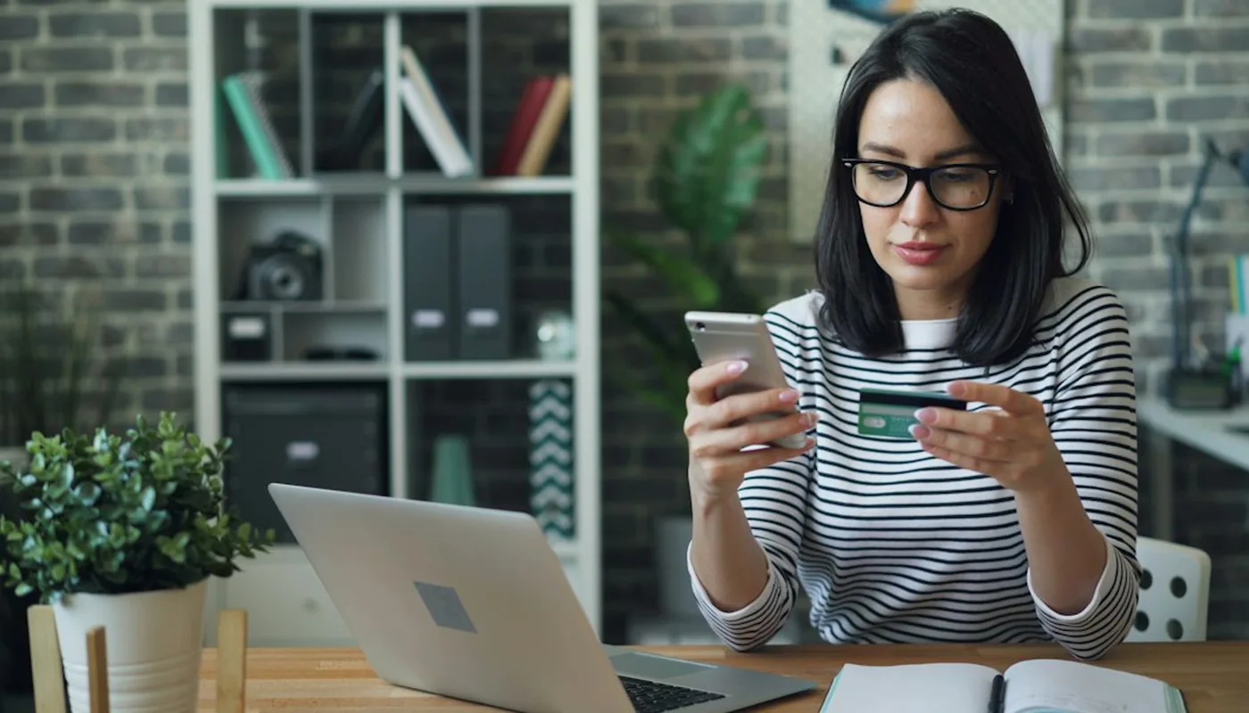 Debit card and smartphone on a desk during real money Australian wagering account verification