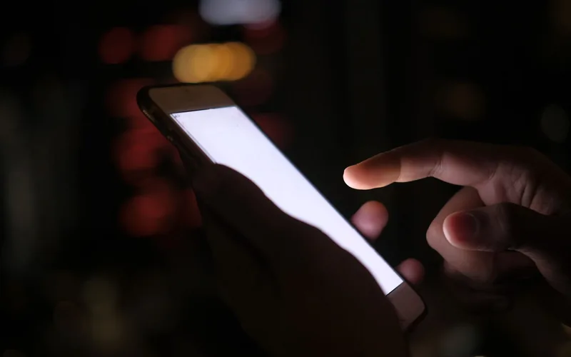 Hands holding a smartphone open on a mobile bet slip used by aussie racing punters